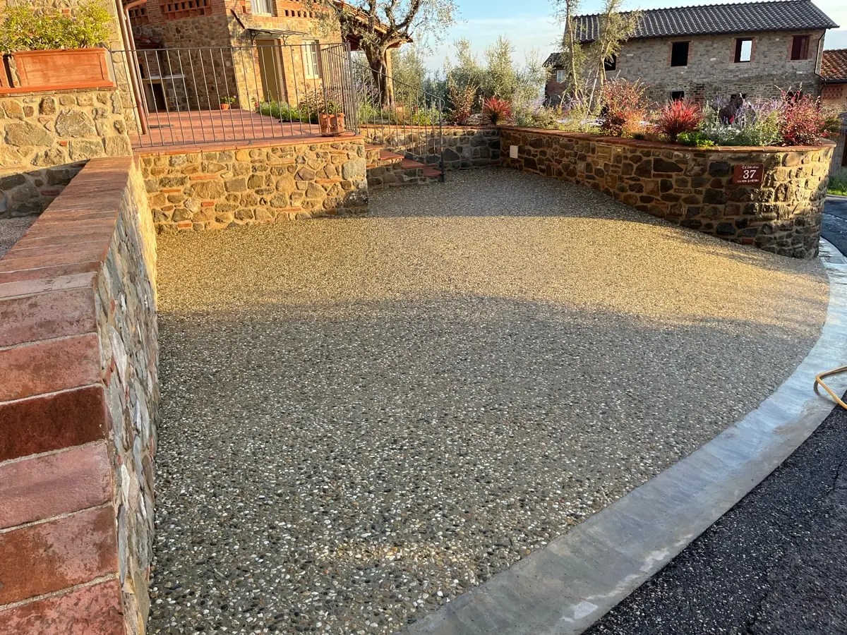 Corte in sasso lavato tra muri in mattoni e pietra