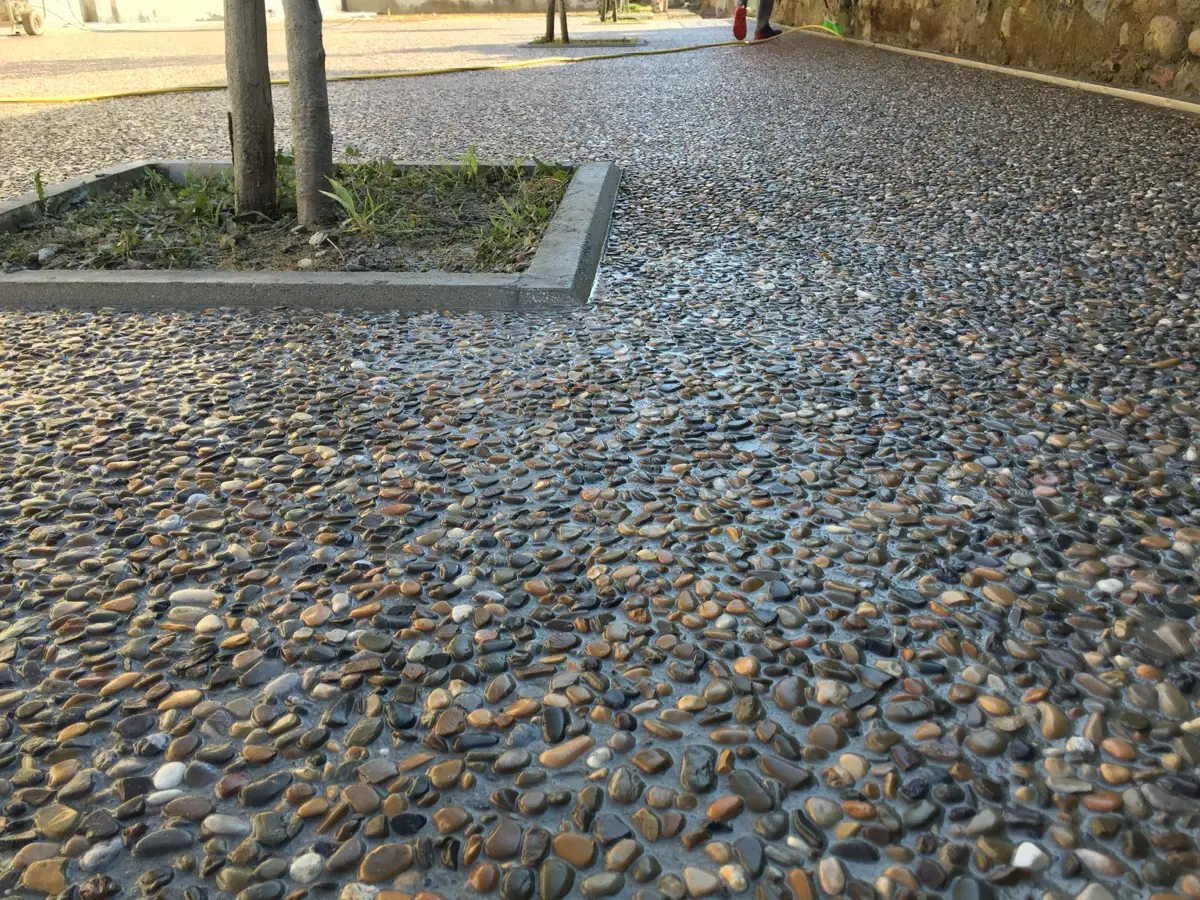 Piazza in sasso lavato con un'aiuola alberata al centro