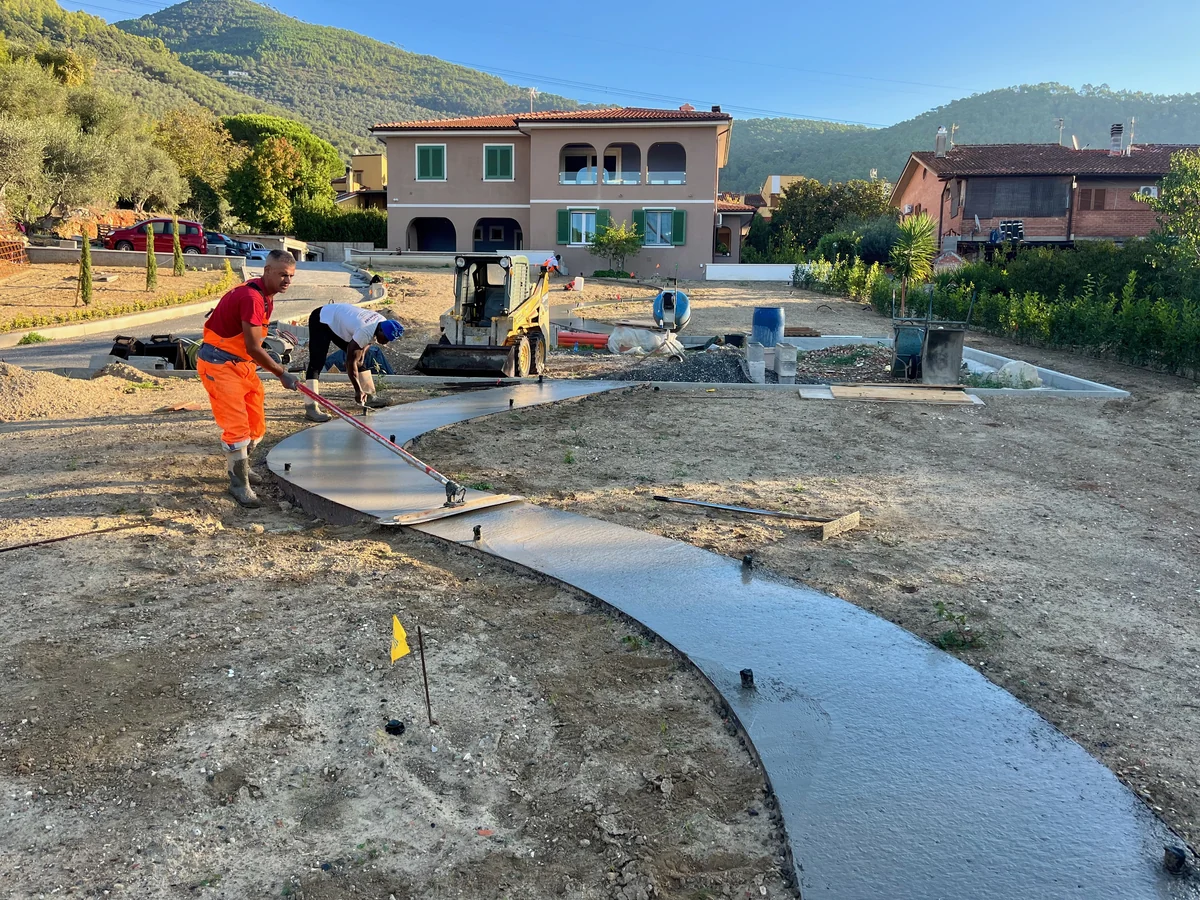 Getto di un vialetto curvo in sasso lavato nel giardino di una villa