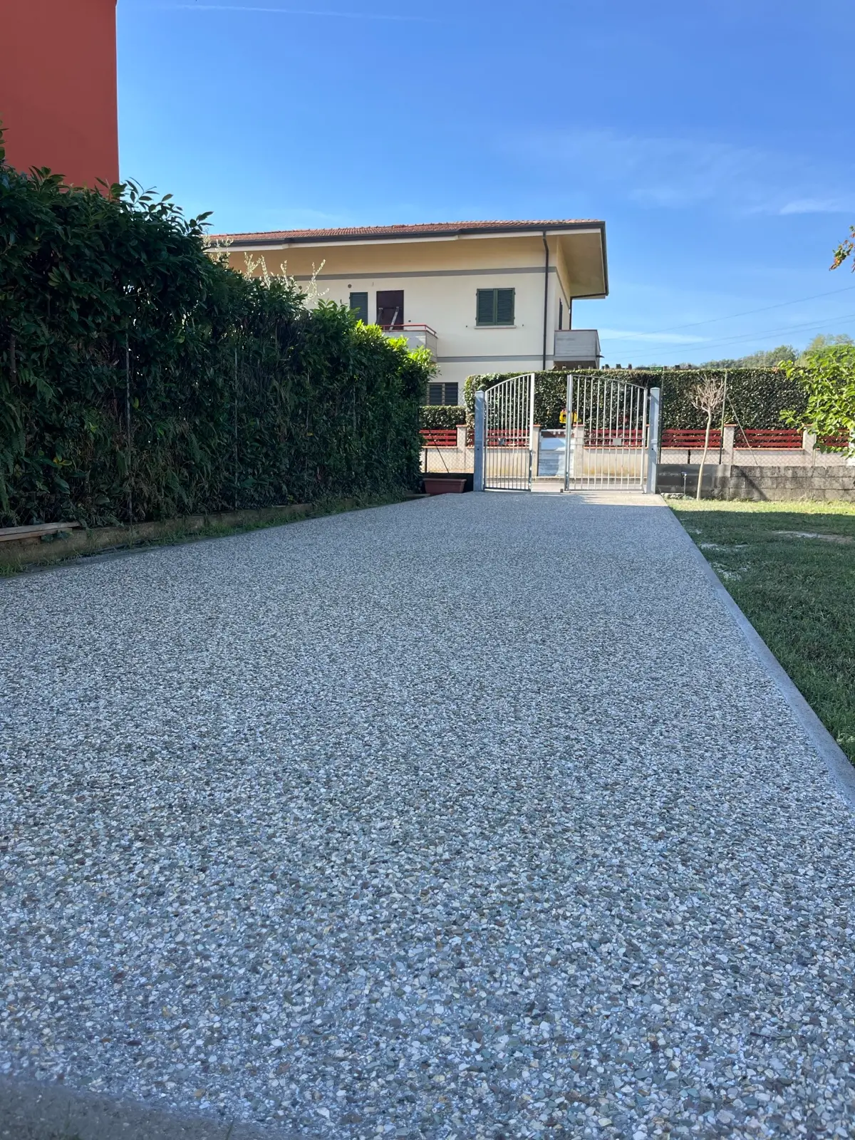 Vialetto d'ingresso in sasso lavato verso il cancello di casa