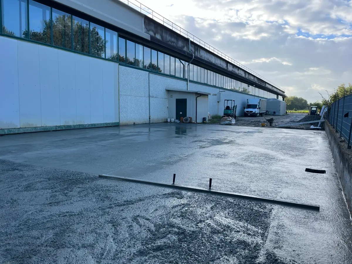 Getto di un piazzale in calcestruzzo davanti a un capannone