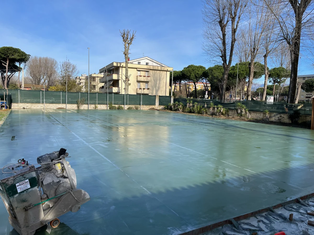 Platea esterna in calcestruzzo appena lisciata, con la macchina per il taglio dei giunti in primo piano